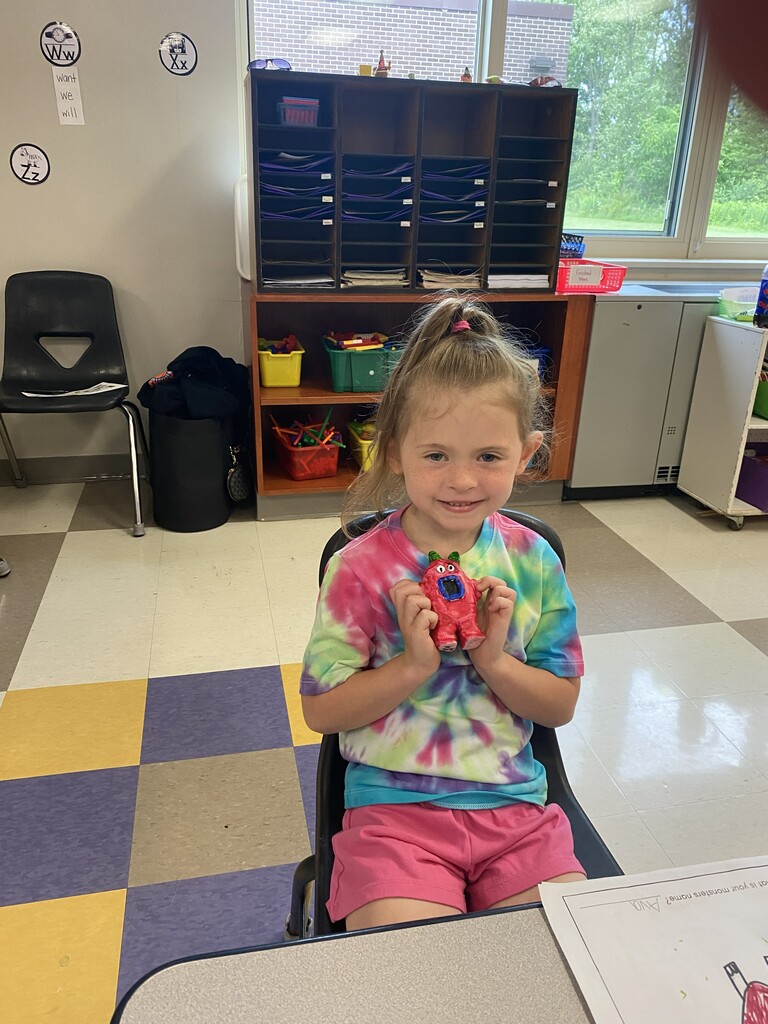 kindergartener holding clay monster