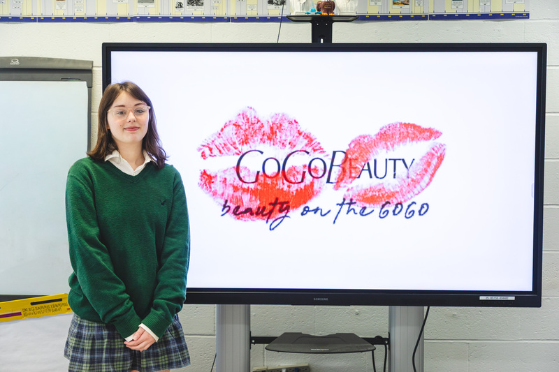 girl standing next to smart board with logo of business