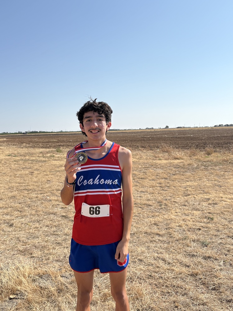 High school runner holding his medal after a race