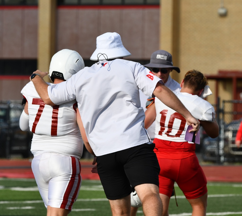 Coach talking with football player