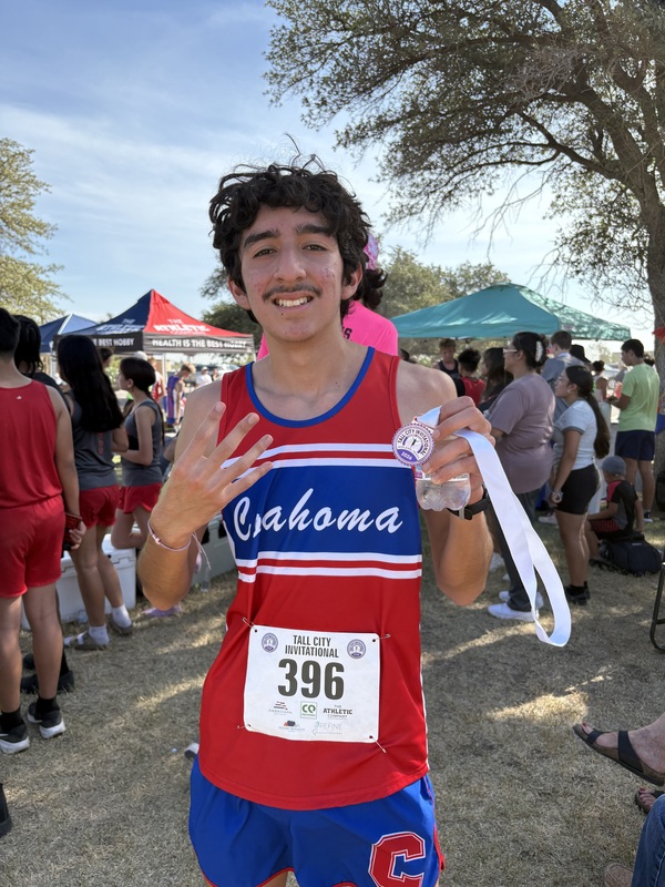 High school runner posing with his medal