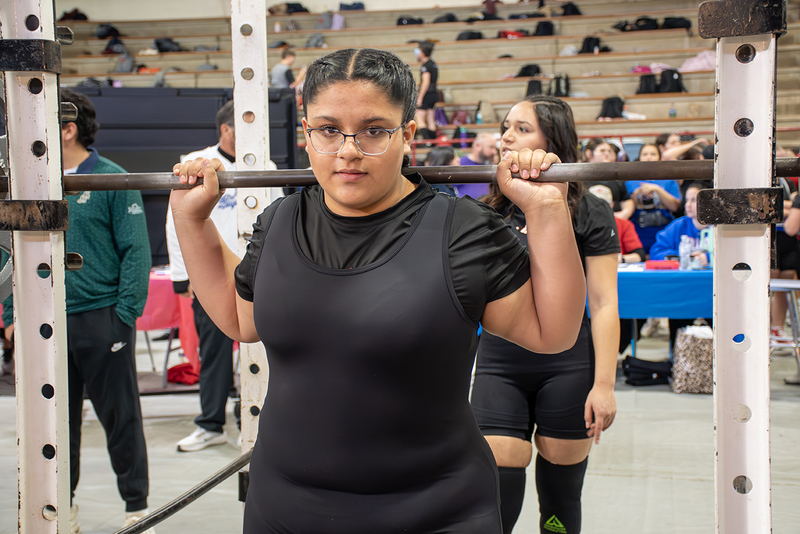 High school girl about to lift weights