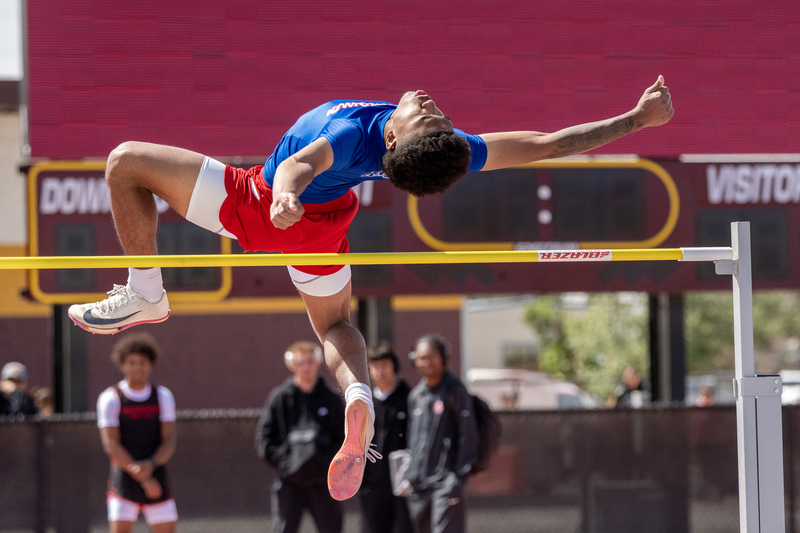 High school track competitor competing at high jump clearning the bar