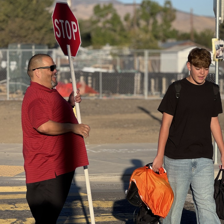 Mr. Garza at crosswalk duty with a student