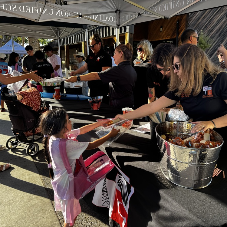 District staff pass out school supplies at National Night Out