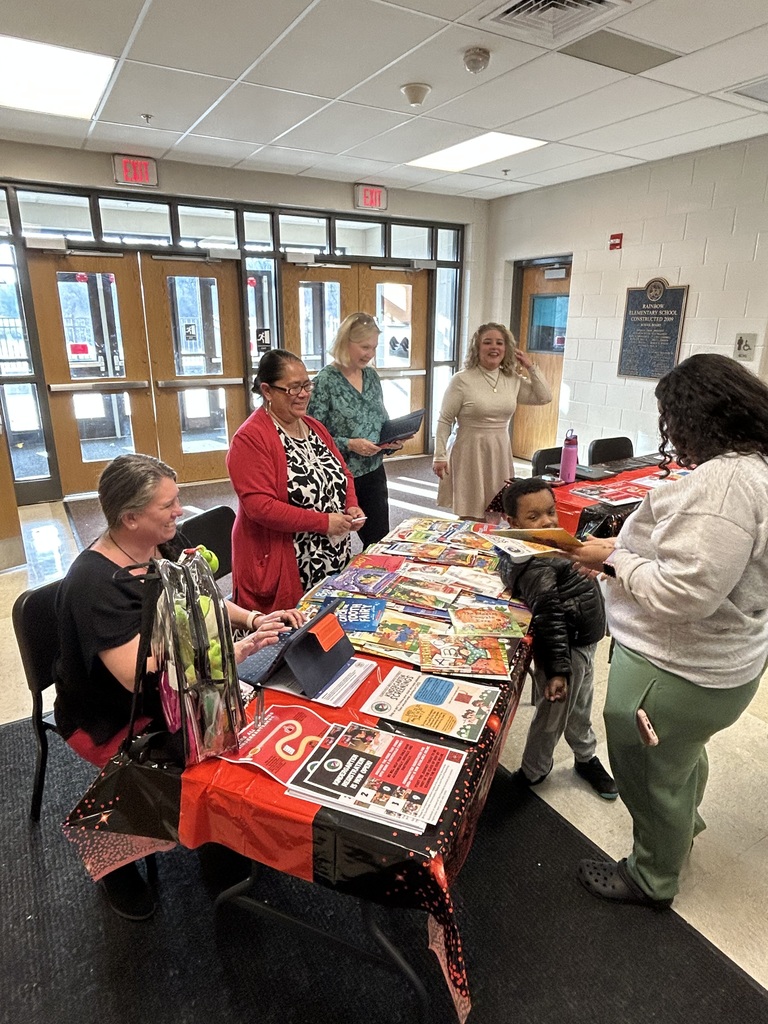 School admin giving out books and helping carnival goers.
