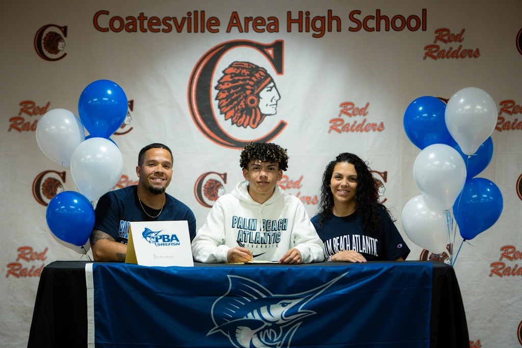 Picture of Andrew Winianas signing with his parents.