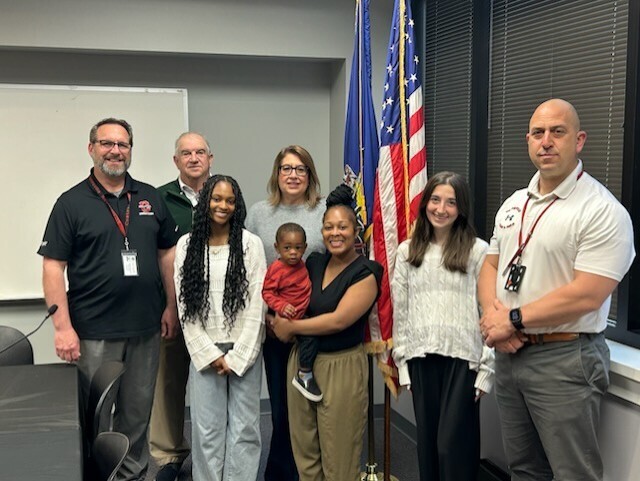 Angel Johnson with her mother and brother, members of the Coatesville Community Education Foundation, the CASD Superintendent, and her high school principal.