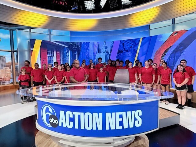 Red Raider Marching Band posing for a picture beind the news desk at 6ABC.