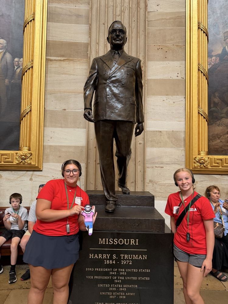 two students posing with the Missouri/ Truman statue
