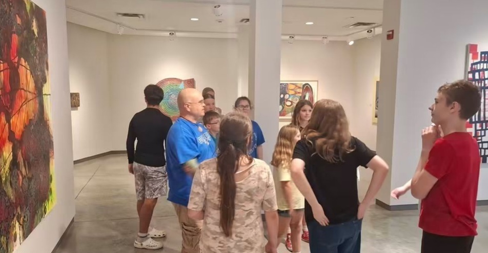 Elementary art teacher Mr. Belle discusses how to curate a collection of artwork with junior high art students at the Faum Museum.
