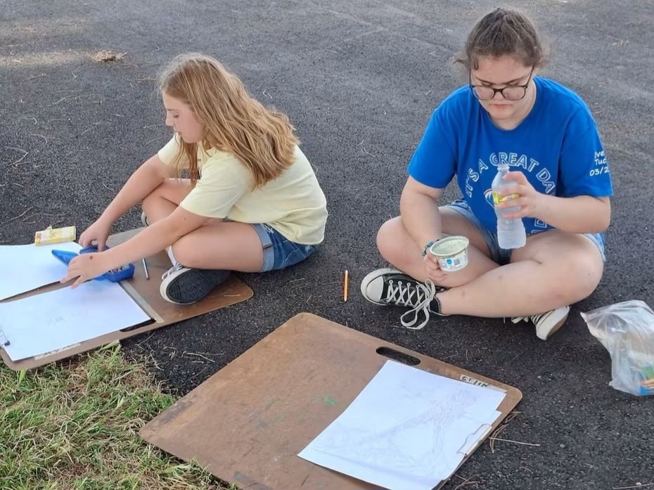 Students Ava Teiberis and Everly Tucker work diligently on artwork.