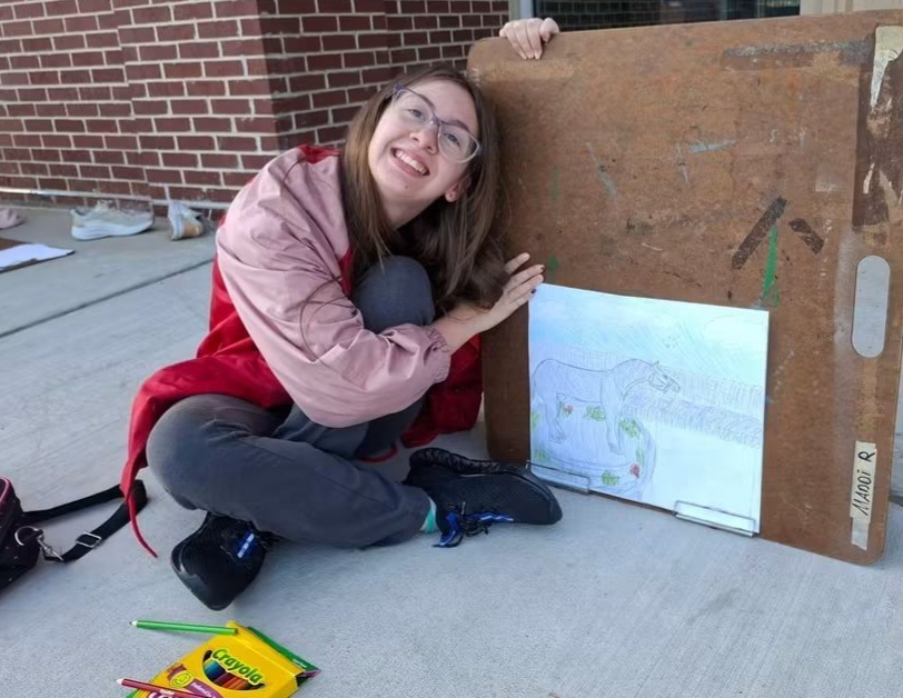 Student Tilly Ahlers proudly displays her drawing of the bronze horse sculpture.