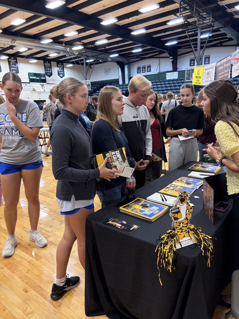 Several high school students talking to college representative.
