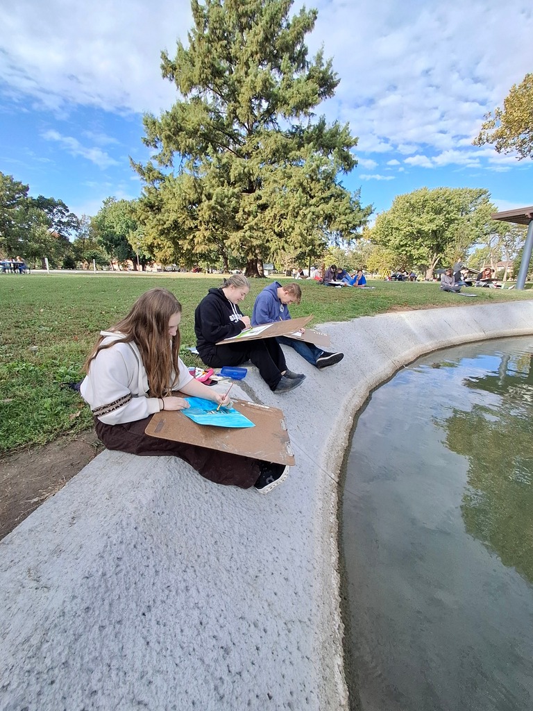Artists Ava Barklage, Madi Root, and Jaxon Alleman working on their artworks.