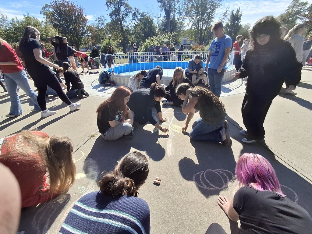 Cole Camp artists working together to make a sidewalk chalk design.