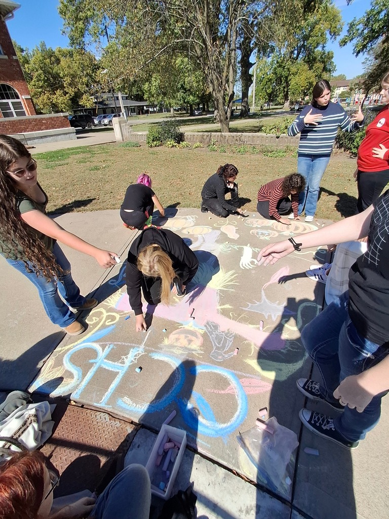 Cole Camp artists working together to make a sidewalk chalk design.