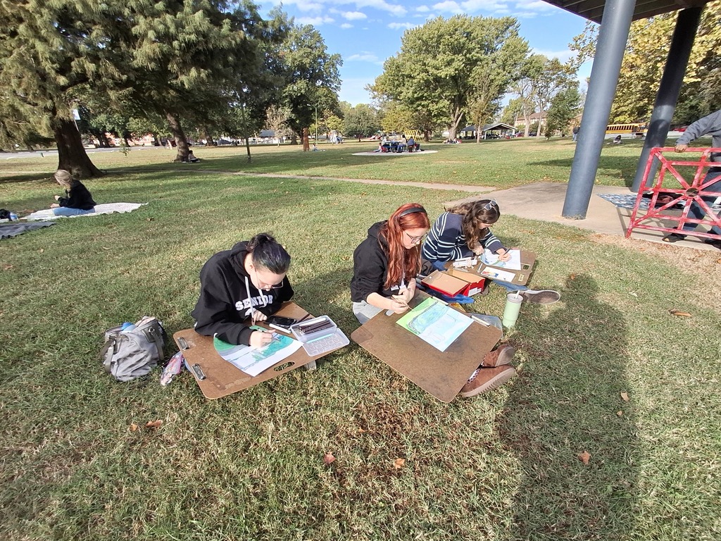 Artists Jaiden Brown, Eva Demoss, and Veda Lutjen working on their artworks.