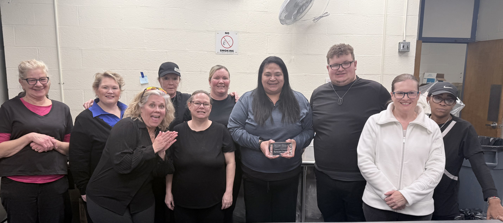 a group of employees stand together to celebrate Kathleen