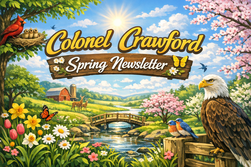 “Colonel Crawford Spring Newsletter banner showing a bright spring landscape with a golden sunrise, green fields, blooming flowers, and a bald eagle perched on a fence. The text ‘Colonel Crawford Spring Newsletter’ appears in gold and white lettering above a wooden sign, with butterflies and birds symbolizing renewal.”