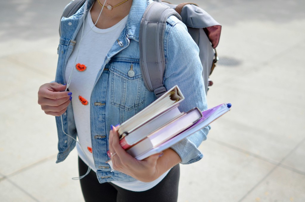 Girl carrying books and backpack