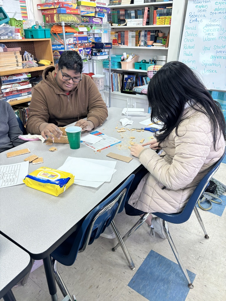 Students building gingerbread house