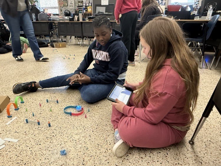 students working with robot through maze