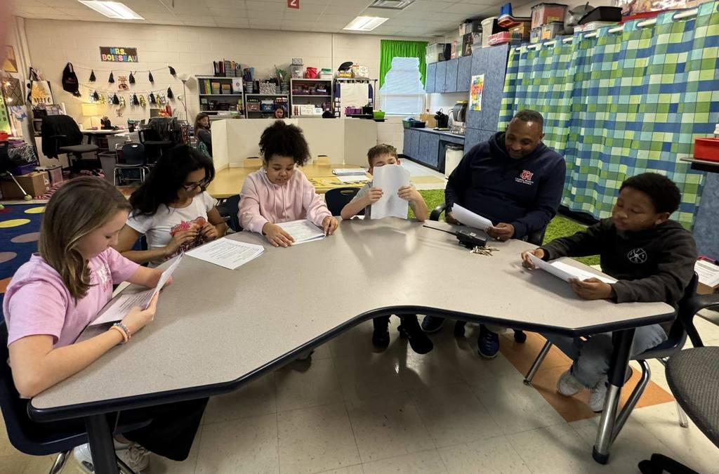students reading with their Principal