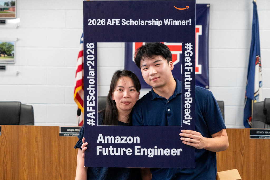 student and mom posing with scholarship frame