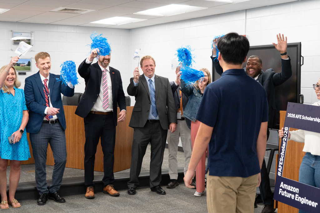 student walking into room with leaders cheering