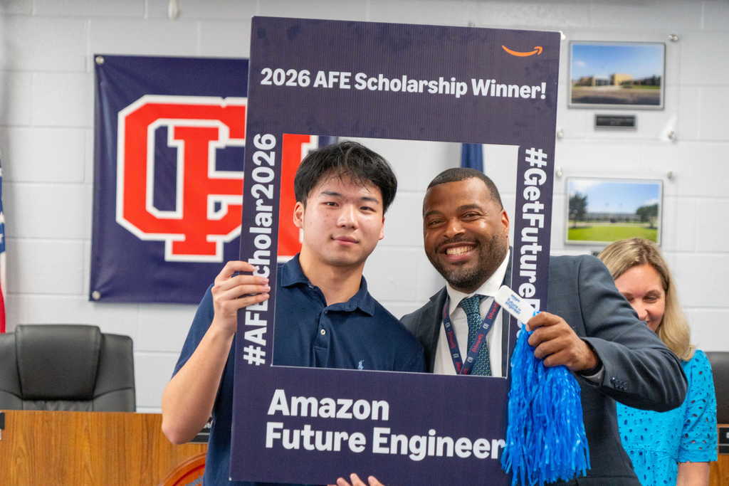student and superintendent with scholarship frame
