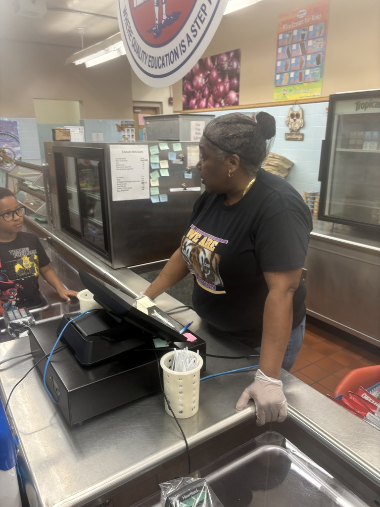 Cafeteria workers helping students pay for lunch