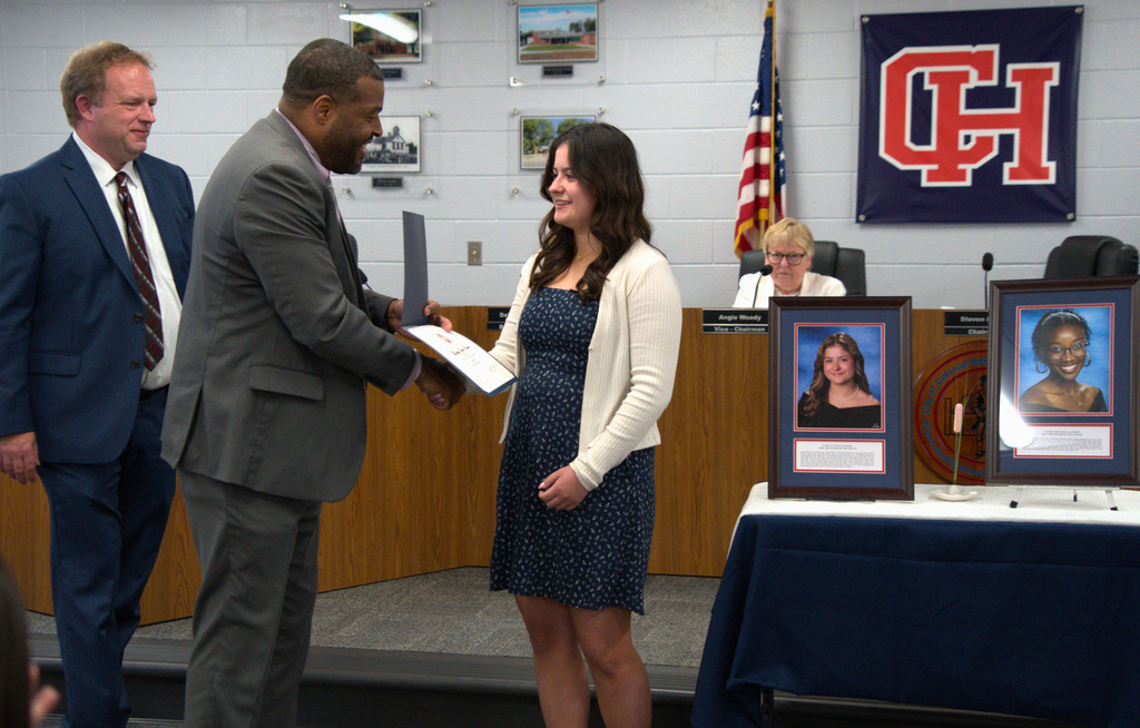 Superintendent shaking hands with senior of the month student