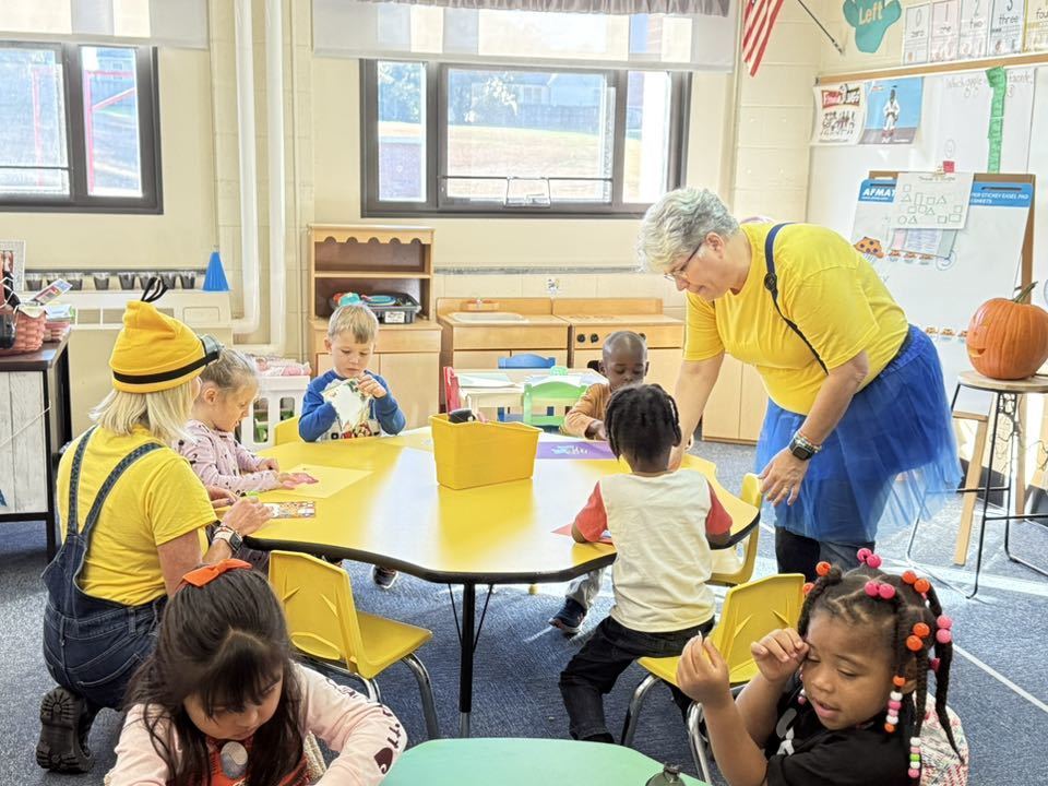 PreK teacher helping students with activity