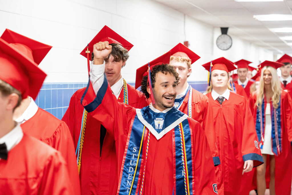 Graduate celebrating with fist in the air during the senior walk