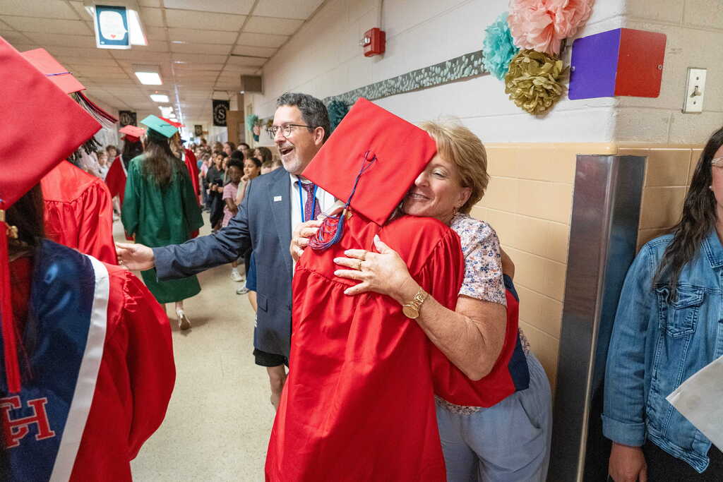 Teacher hugging graduate