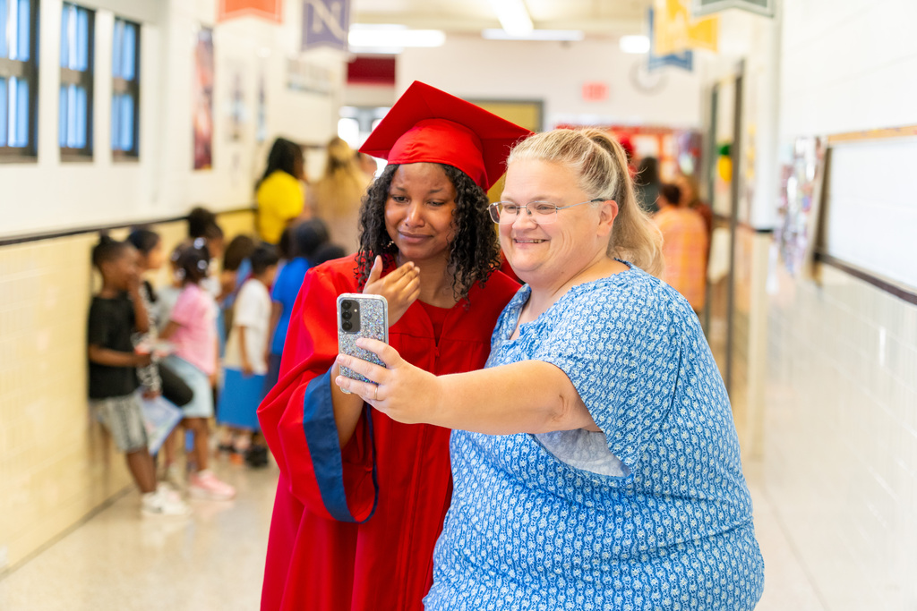 Teacher taking picture with graduate