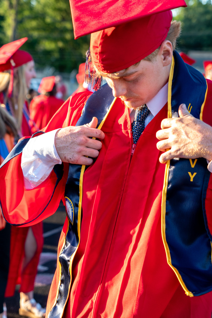 Boy Putting on Graduation Regalia