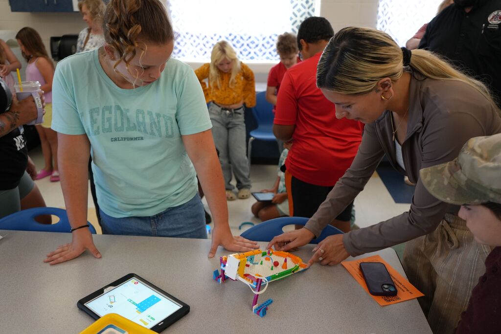 Girl Teaching Parent Lego Game With Ipad