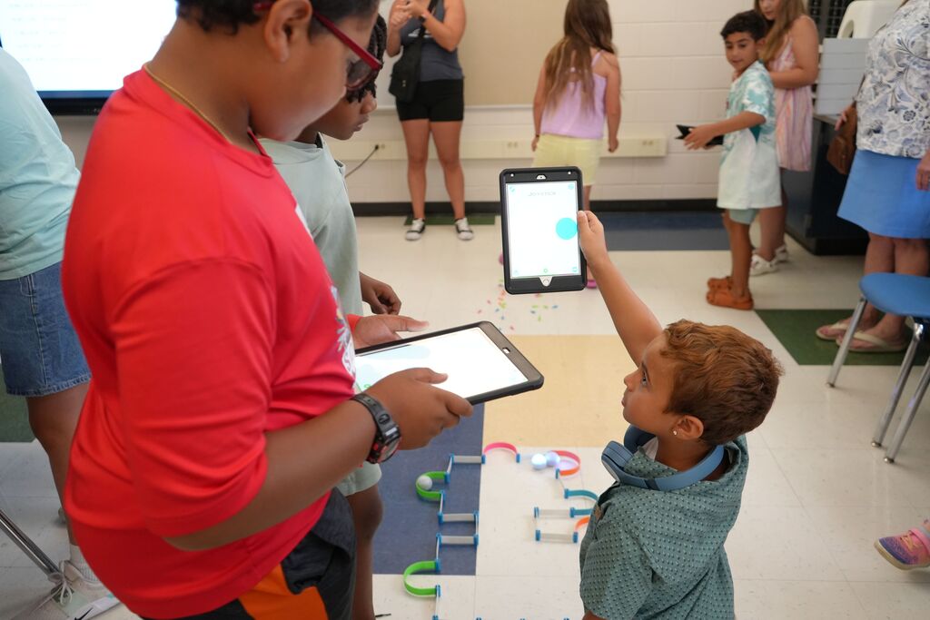 Boys Teaching Small Boy How to Use iPad