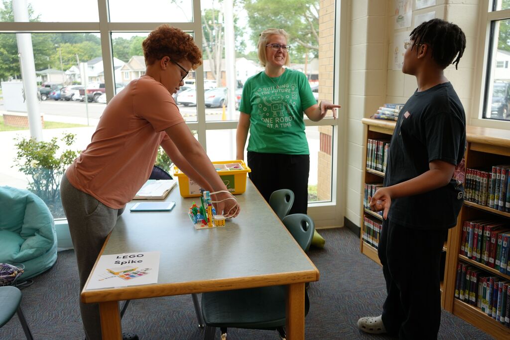 Teacher with Summer Camp Kids Setting Up Legos