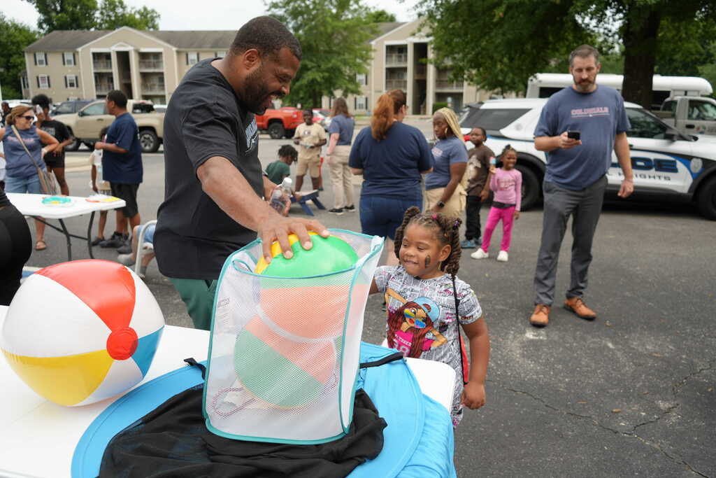 Superintendent Handing Girl a Ball