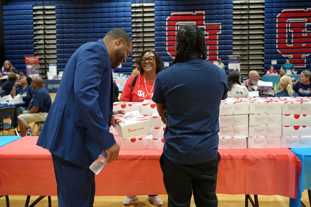 superintendent with lunch laughing with employee