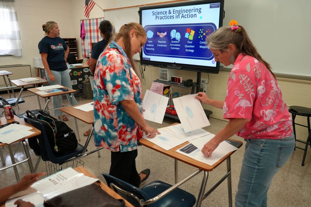 CHPS Teachers Looking at Science Papers in Collaborative Group