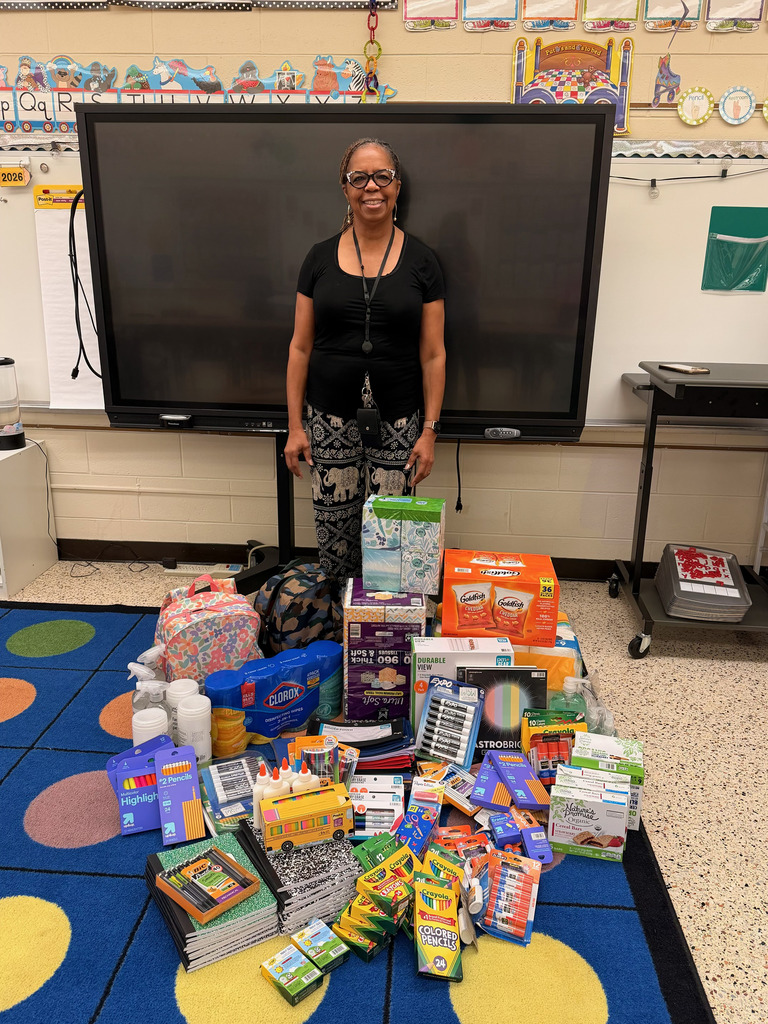 Principal standing with school supplies donation