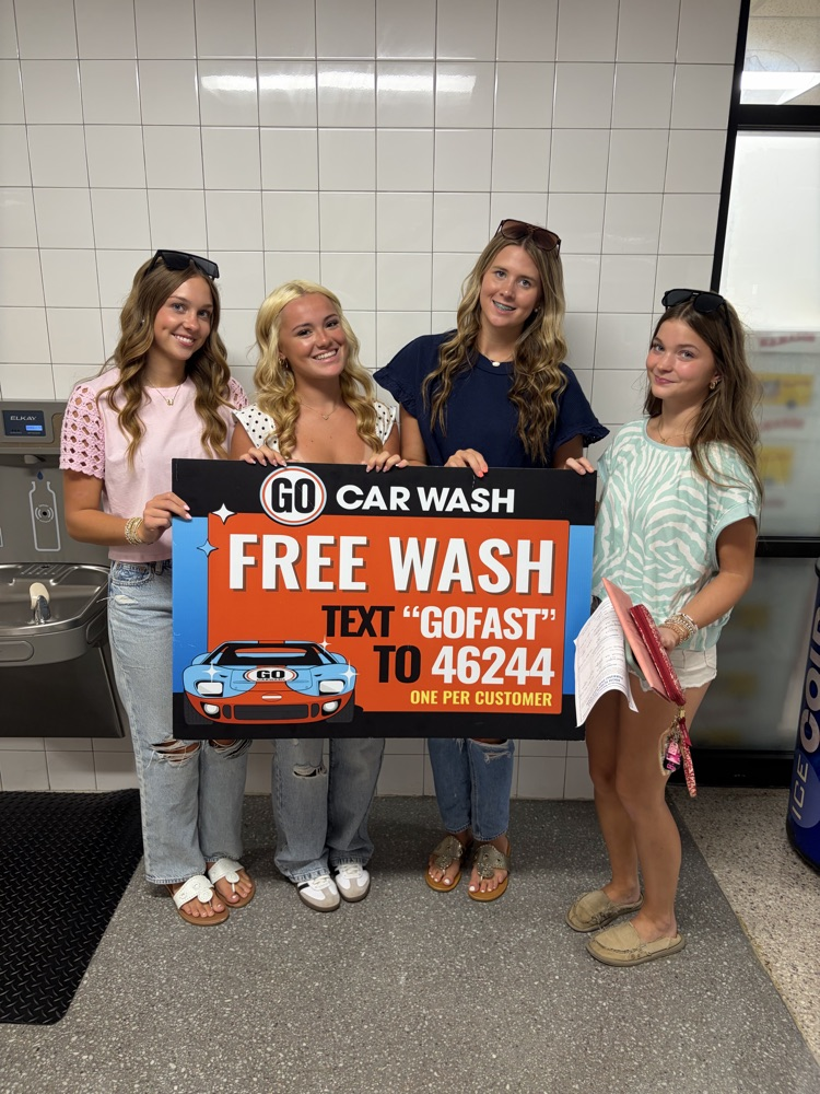 pictures of 4 students holding a Go Carwash sign