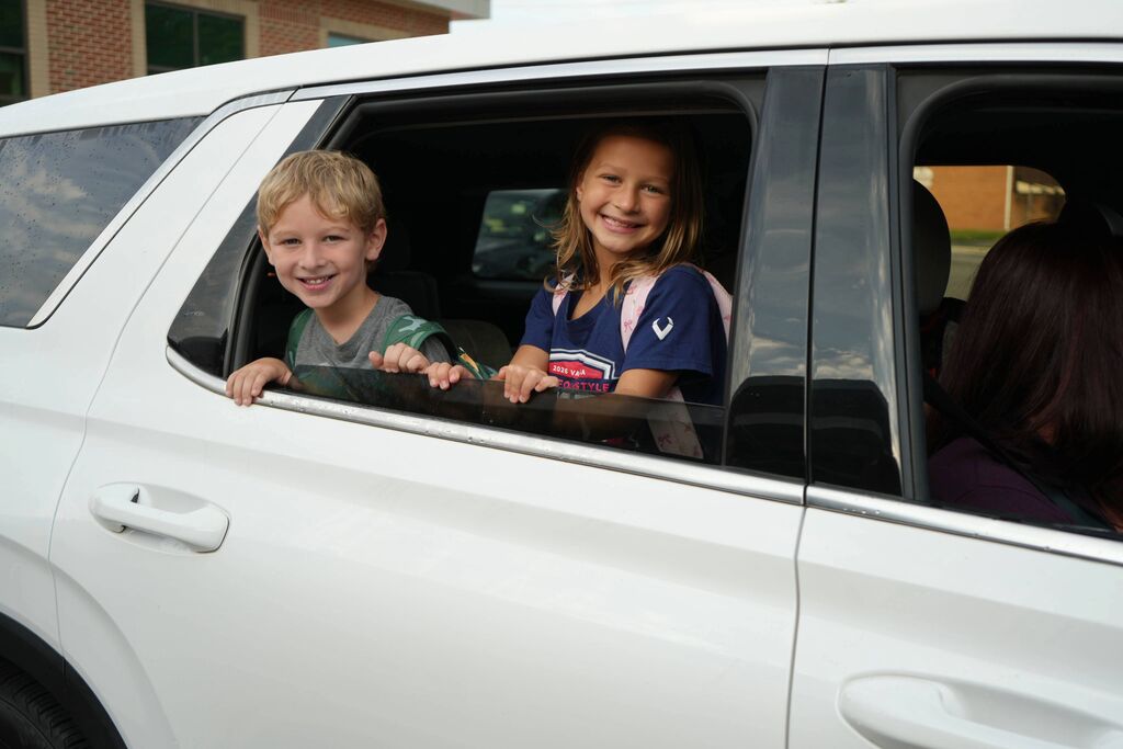 Kids Smiling Out of Car Window