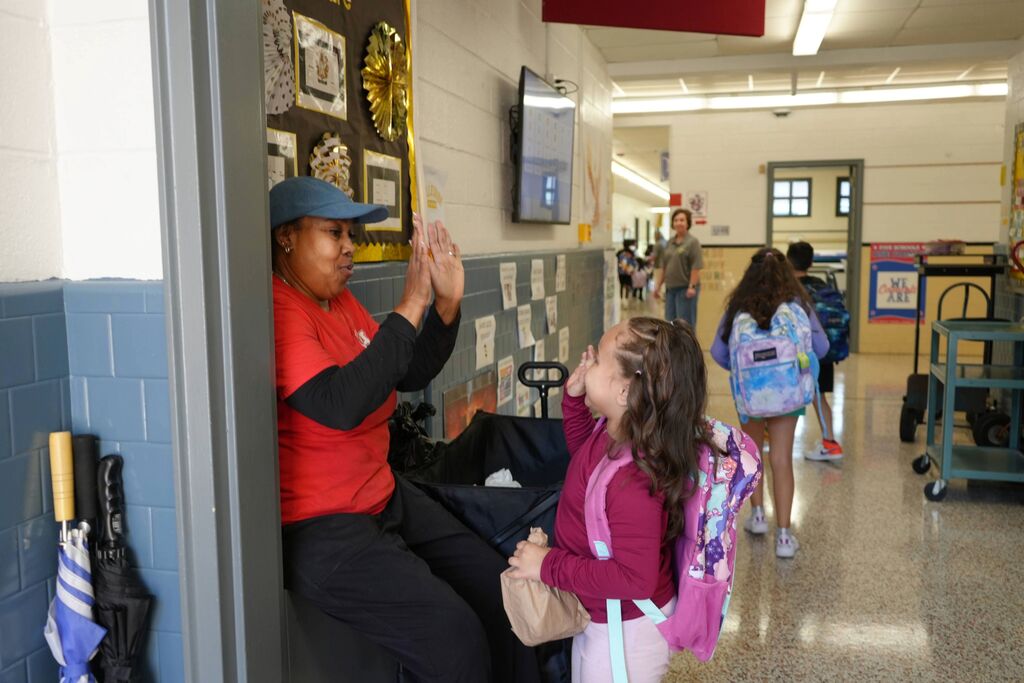 Cafeteria worker high fiving student