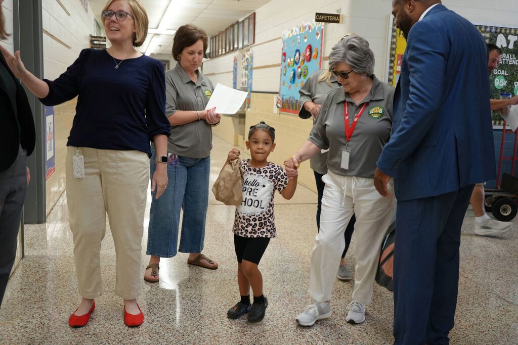 New Student walking to class with adult and her breakfast