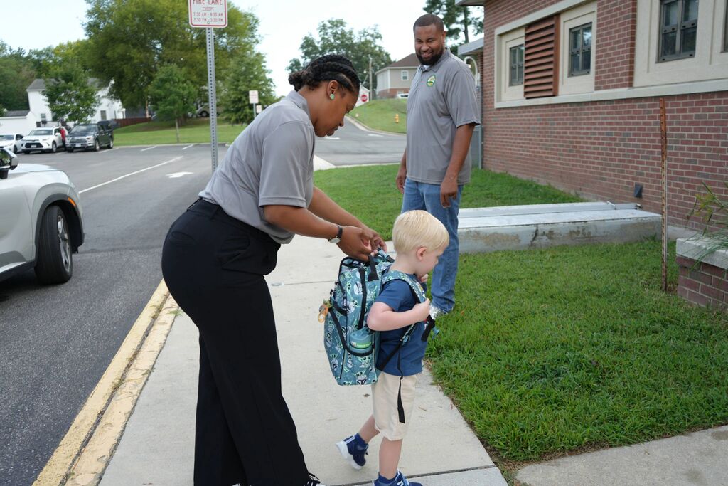 Assistant Pricnipal helping student with backpack